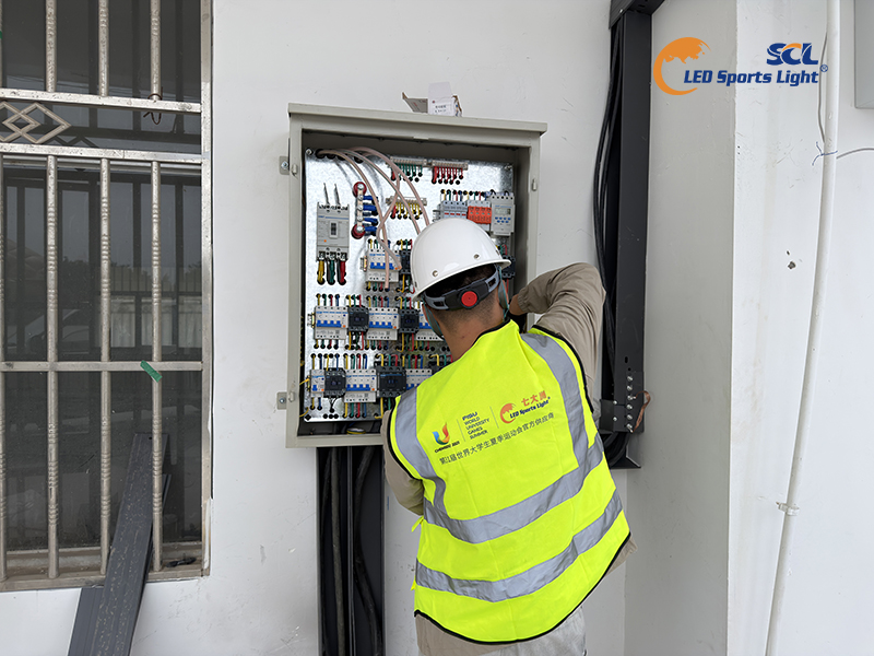 Engineer debugging intelligent electrical control box for stadium LED lighting zoning control system